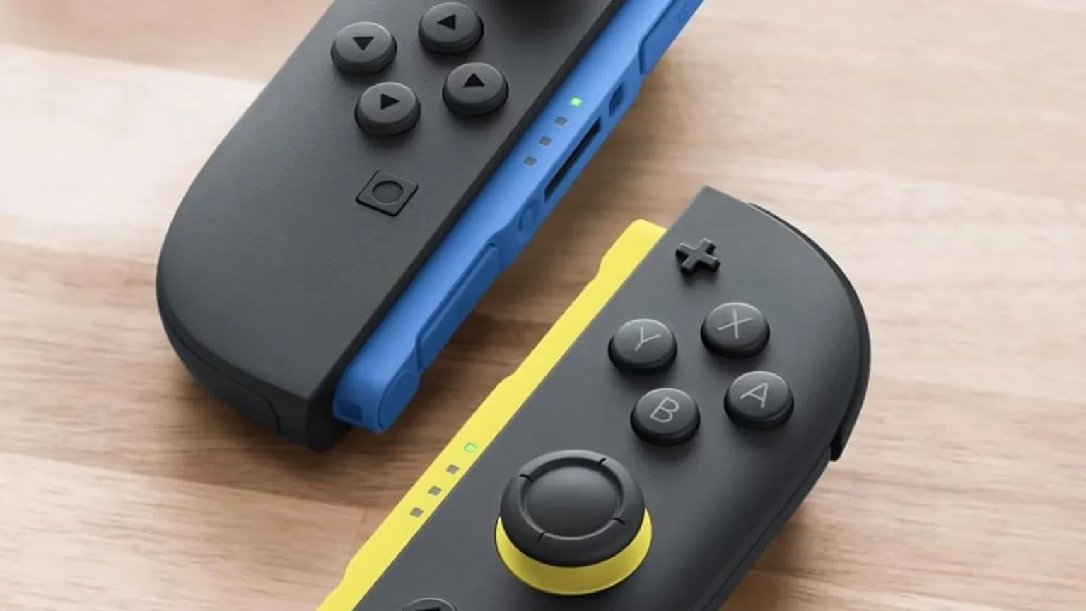 Mandos Joy-Con de colores azul y amarillo sobre una superficie de madera.