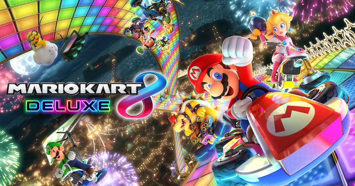 Mario y otros personajes compiten en karts en una colorida pista de Mario Kart 8 Deluxe.